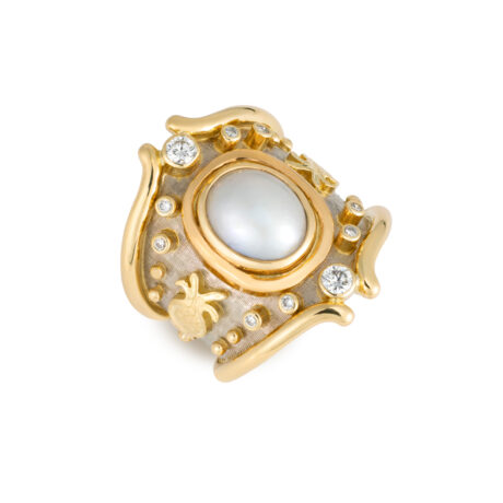 18ct yellow and white gold Heliotrope ring with an oval mabé pearl, pomegranate diamond motifs (0.34cts), and a white gold linen-textured background.