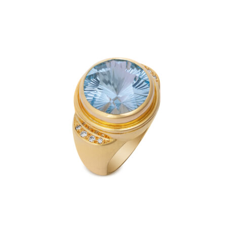18ct yellow gold ring featuring an 11.22ct fancy-cut blue topaz with pavé-set diamond shoulders (0.11cts) on a polished tapered gold shank.