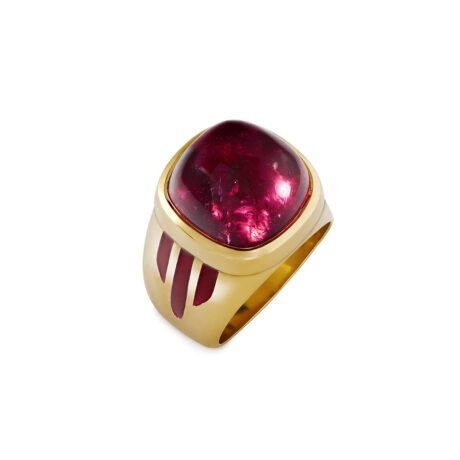 18ct yellow gold ring with a 13.59ct cushion-shaped rubellite cabochon, hand-engraved sides, and red enamel accents. Elegant craftsmanship.